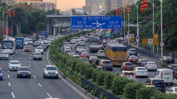 A busy urban highway in China filled with cars, buses, and trucks.