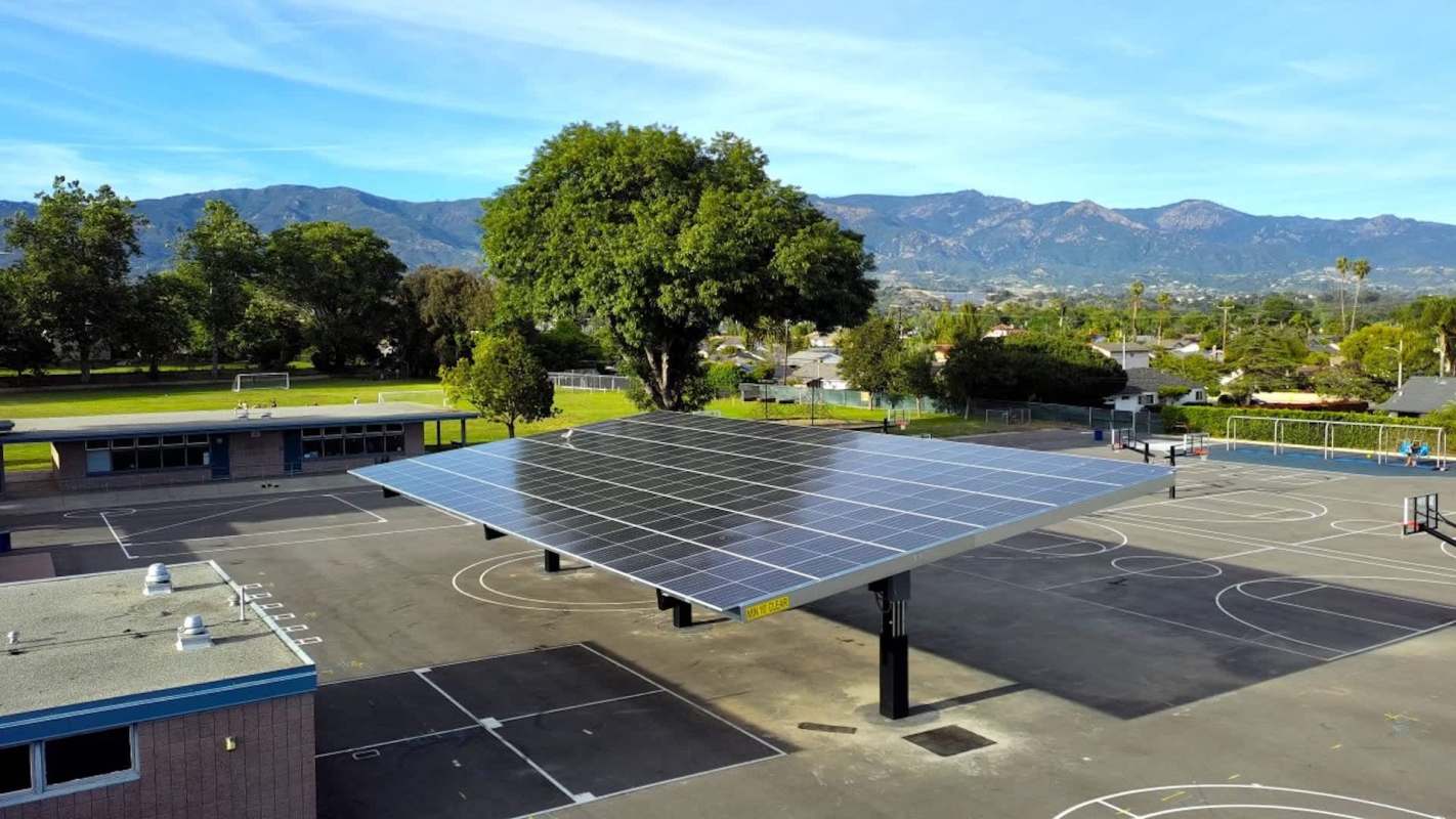 A solar panel structure over a elementary school playground.