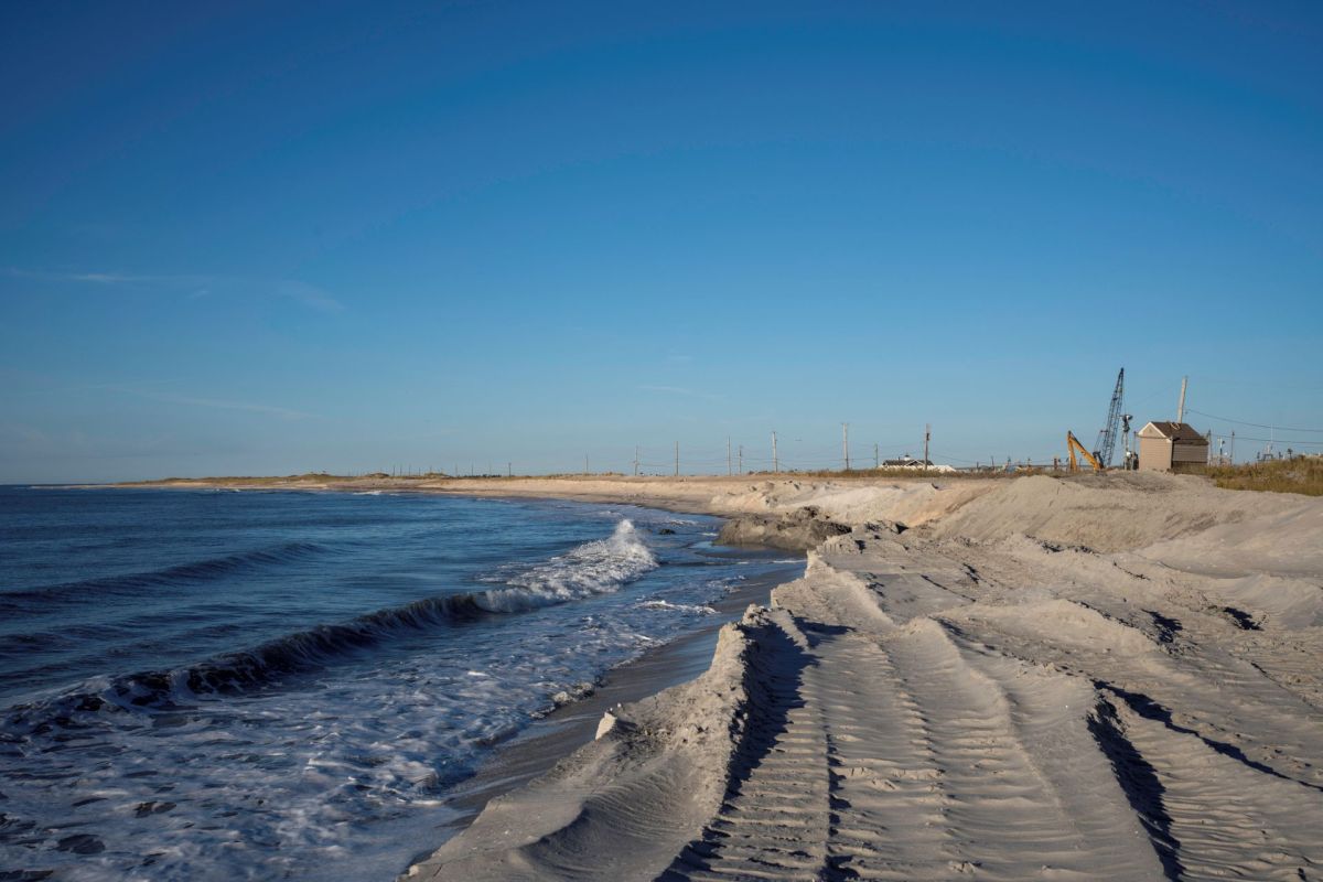 A beach stretches along the shore where there is erosion.