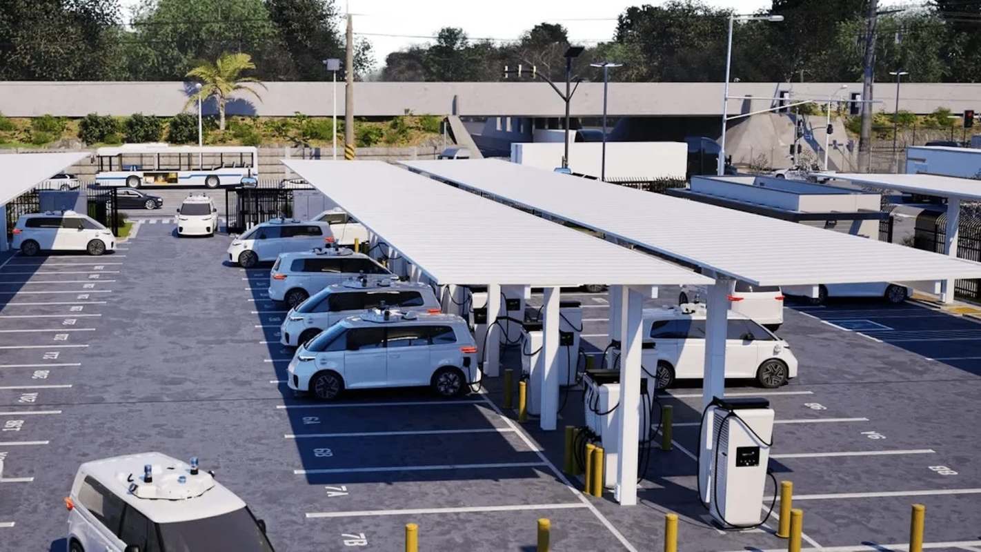 A parking lot with white electric vehicles charging under solar panel canopies.