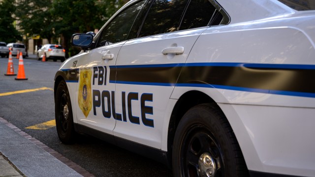 An FBI police car parked near traffic cones.