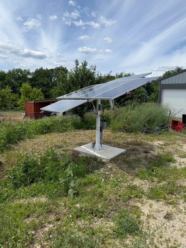 Solar panels on a stand in a yard.