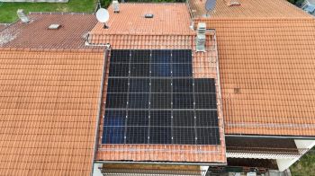 A rooftop covered with solar panels on traditional tile roofing.