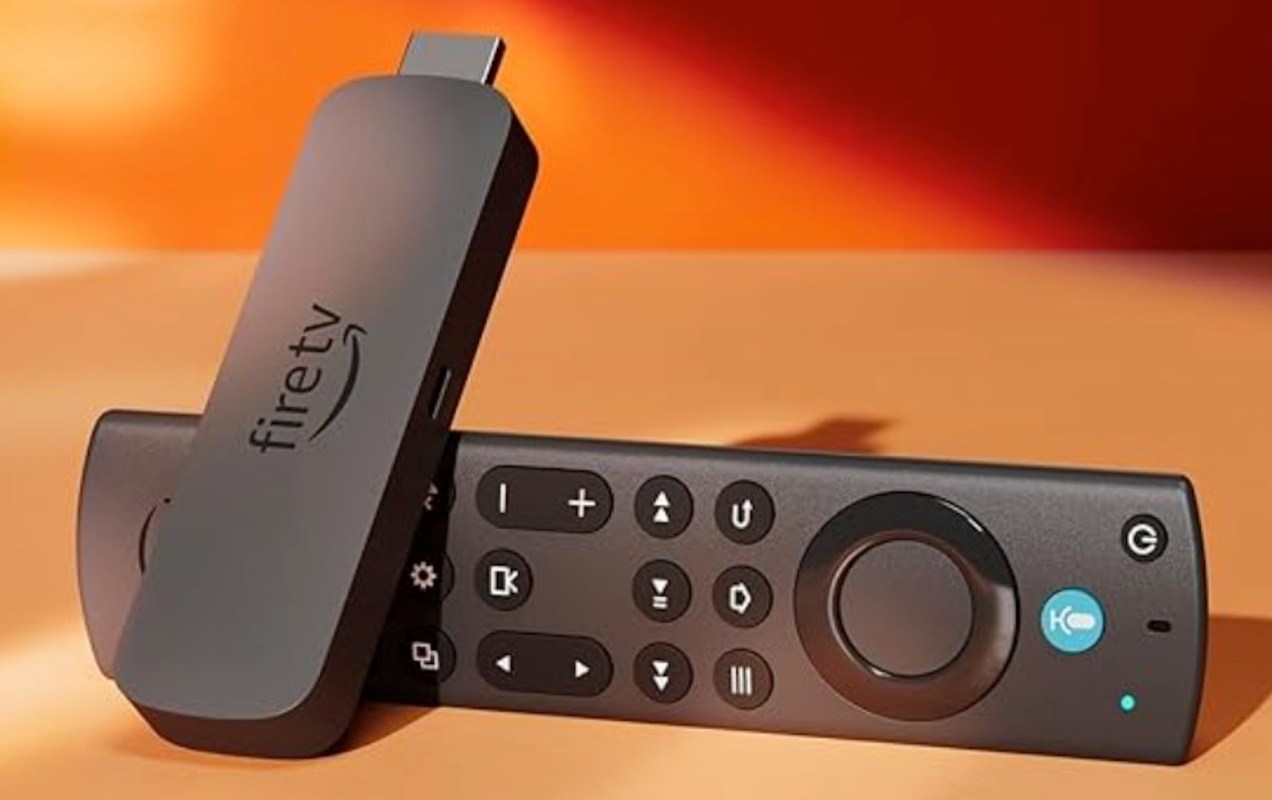An Amazon Fire TV Stick and its remote against an orange background.