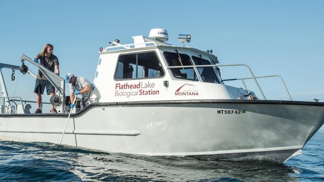 Two researchers work on a boat marked "Flathead Lake Biological Station."