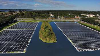 Solar panels installed on a lake with a small island in the center.