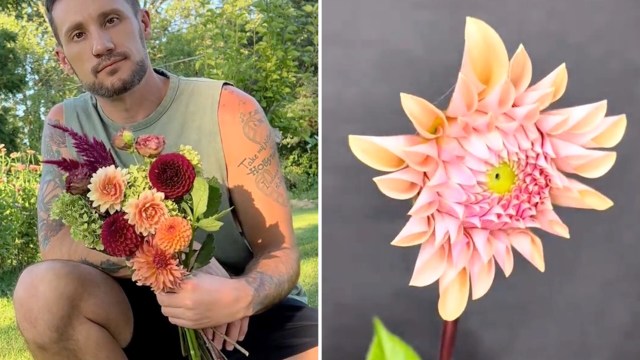A person with tattoos holds a vibrant bouquet of dahlia flowers in a garden setting.