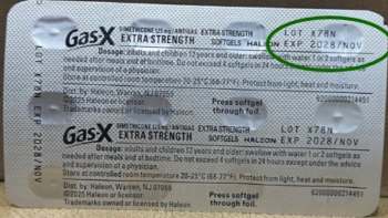 A packet of Gas-X extra strength softgels with dosage instructions and expiration date clearly visible.