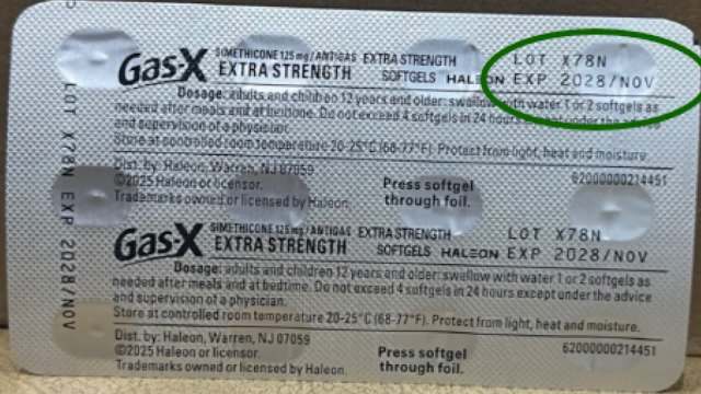 A packet of Gas-X extra strength softgels with dosage instructions and expiration date clearly visible.