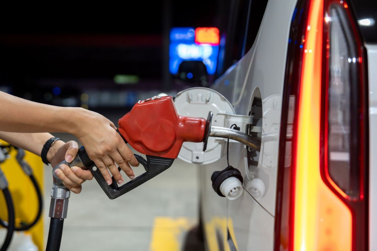 A person refueling a vehicle at a gas station.