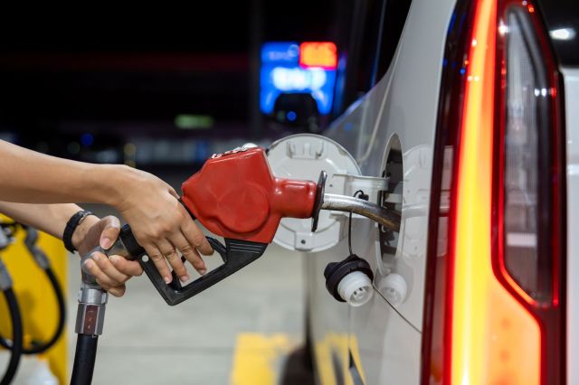 A person refueling a vehicle at a gas station.