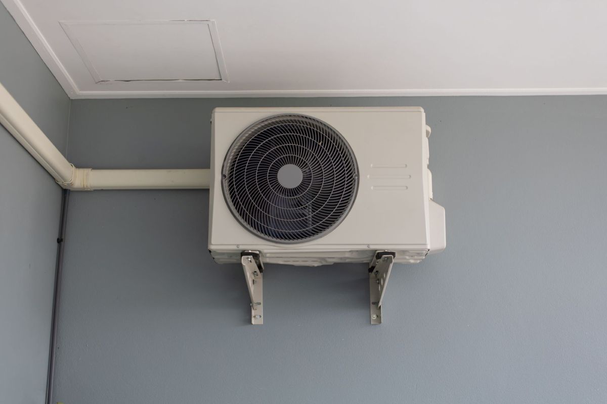 Outdoor heat pump unit mounted beside a home.