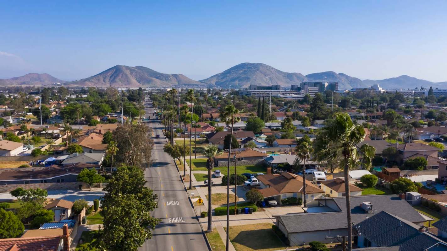Aerial view of a suburban neighborhood with mountains in the background.