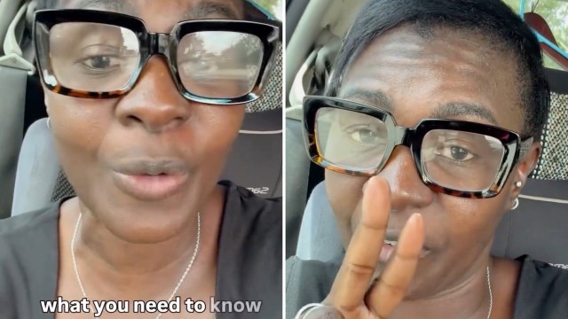 A woman with large glasses speaks into the camera while sitting in a car, gesturing with her hand.