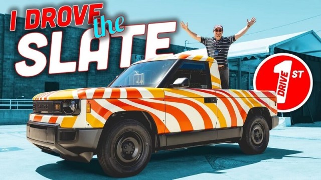 A man raising his arms in joy while standing in the bed of a Slate electric pickup. 