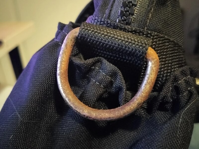 A close-up of some rust on one of the bags' metal rings.