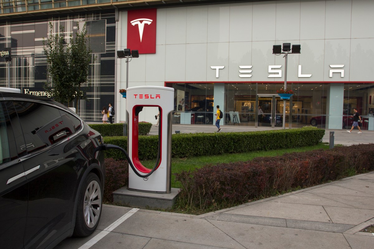 An electric vehicle plugged into a Supercharger outside a Tesla store in China.