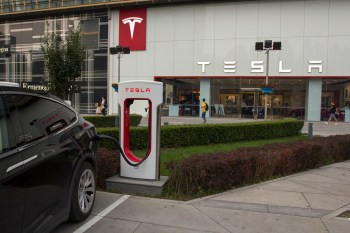 An electric vehicle plugged into a Supercharger outside a Tesla store in China.