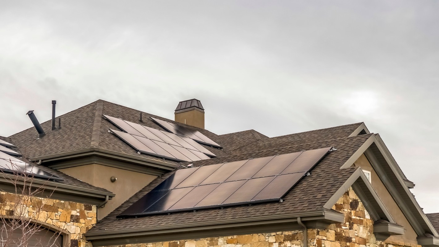 A rooftop with solar panels on a cloudy day.