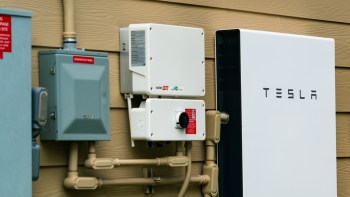 A Tesla energy storage system mounted on a wall.