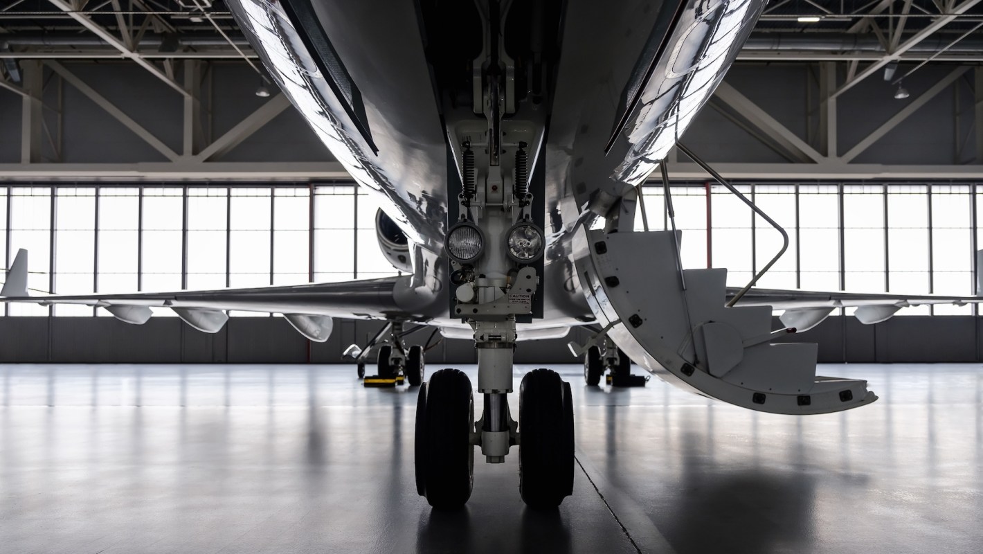 A front view of a private jet in a hangar.