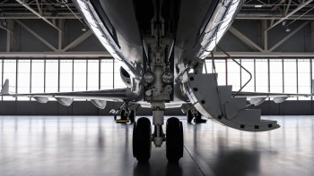 A front view of a private jet in a hangar.