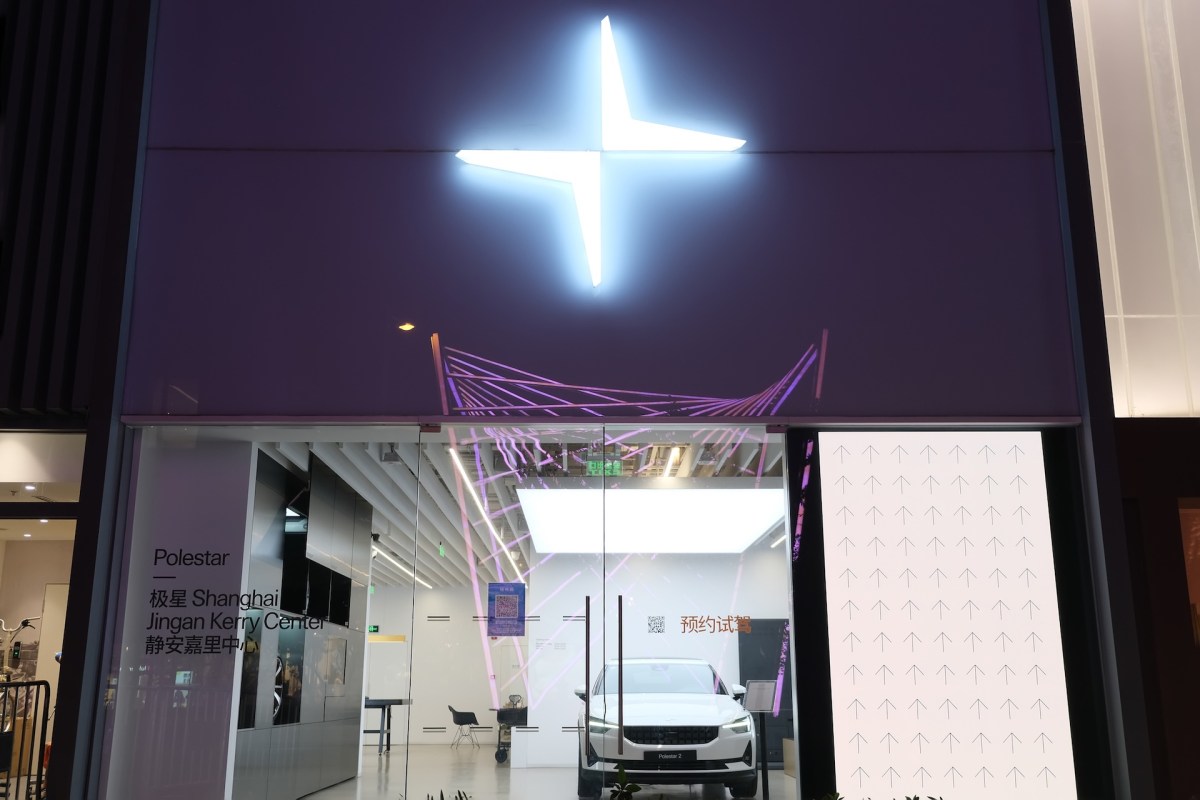 A vehicle in a showroom with an illuminated Polestar logo.