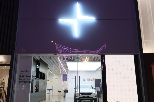 A vehicle in a showroom with an illuminated Polestar logo.