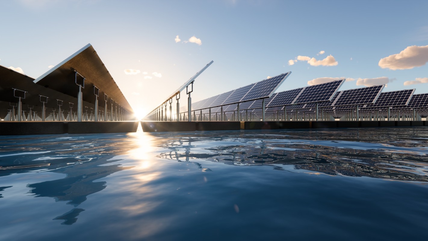 A solar panel farm reflected in calm water under a clear blue sky at sunset.