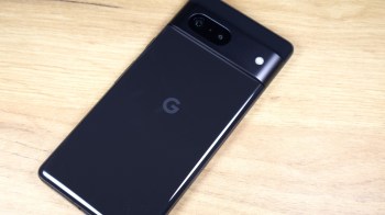 A black smartphone with a "G" logo on its back, resting on a wooden surface.