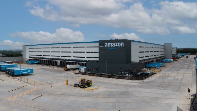 A large Amazon distribution center with loading docks and delivery trucks.