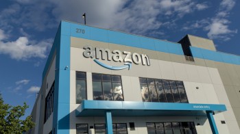 An Amazon building with the company logo, blue trim, and large windows.