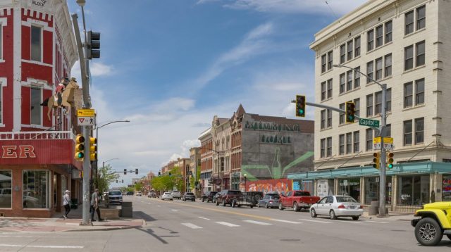 A street scene in Cheyenne, Wyoming, featuring historic buildings, traffic signals, and pedestrians.