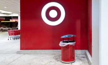 A red wall featuring Target's circular logo and a trash can with a plastic liner nearby.