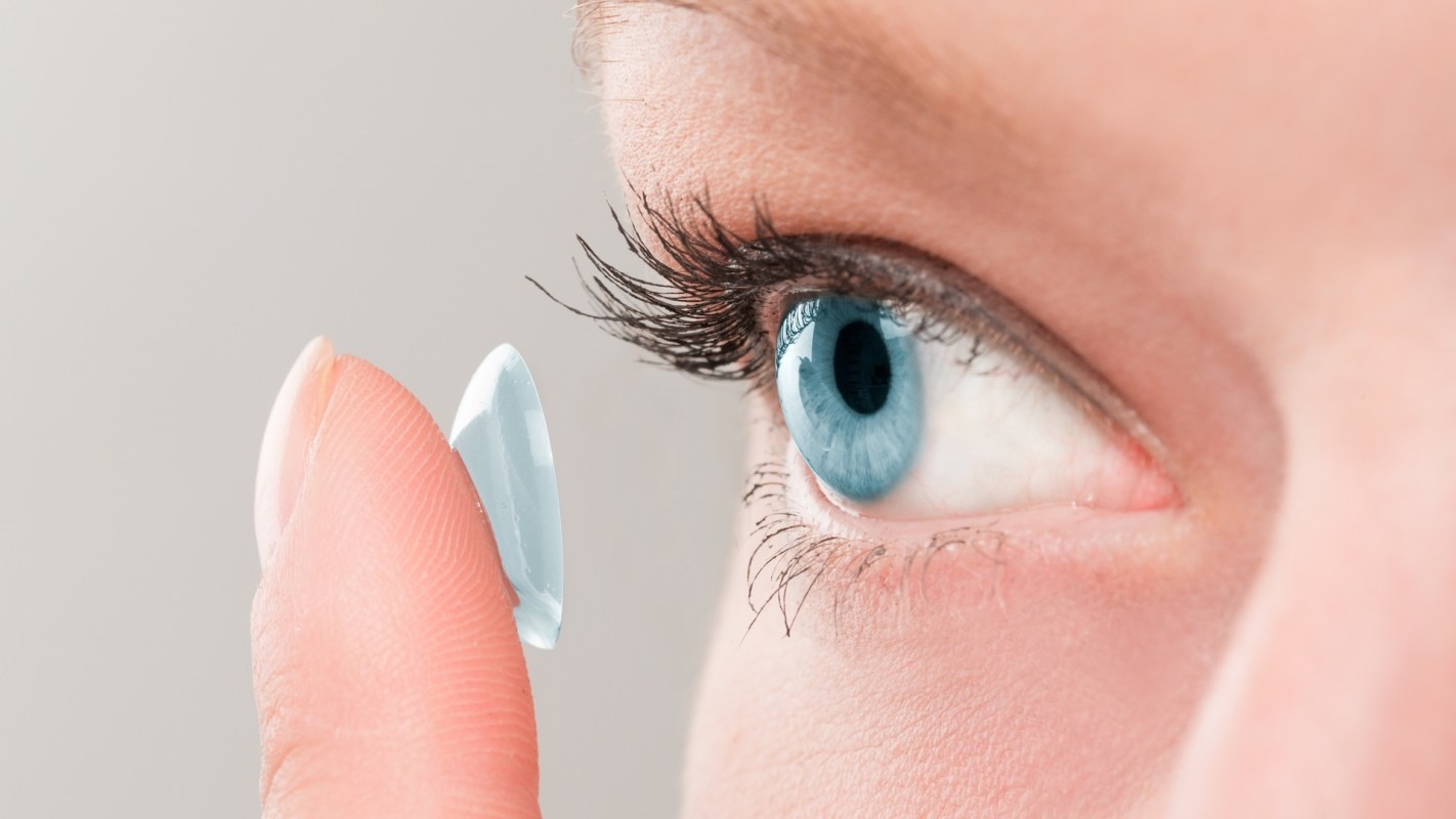 A person putting in a contact lens.