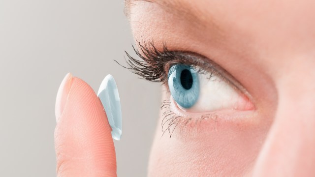 A person putting in a contact lens.