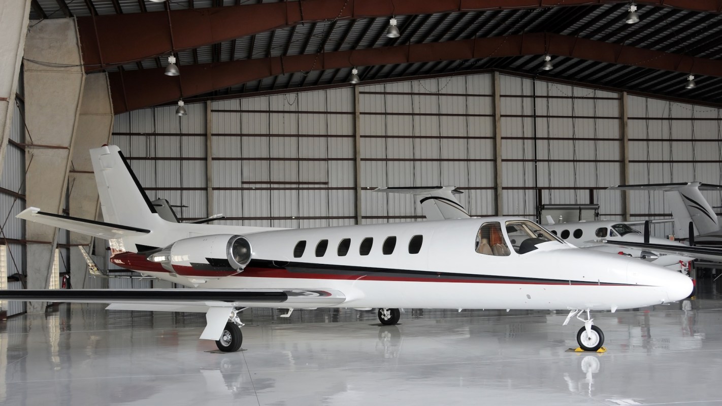 A private jet parked inside a hangar.