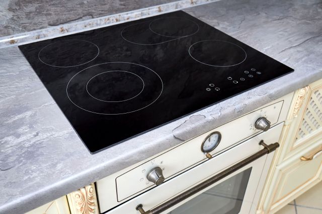 A modern black glass cooktop in a kitchen.