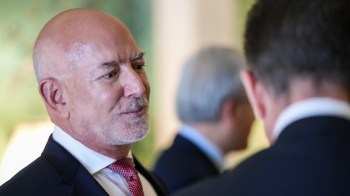 Jeff Bezos engages in conversation, with another person partially visible in the background.