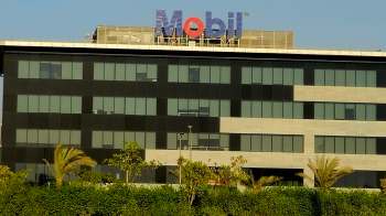 A modern building featuring a prominent blue and red "Mobil" sign on its rooftop.