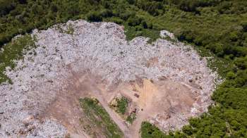 An aerial view of a large landfill surrounded by greenery.