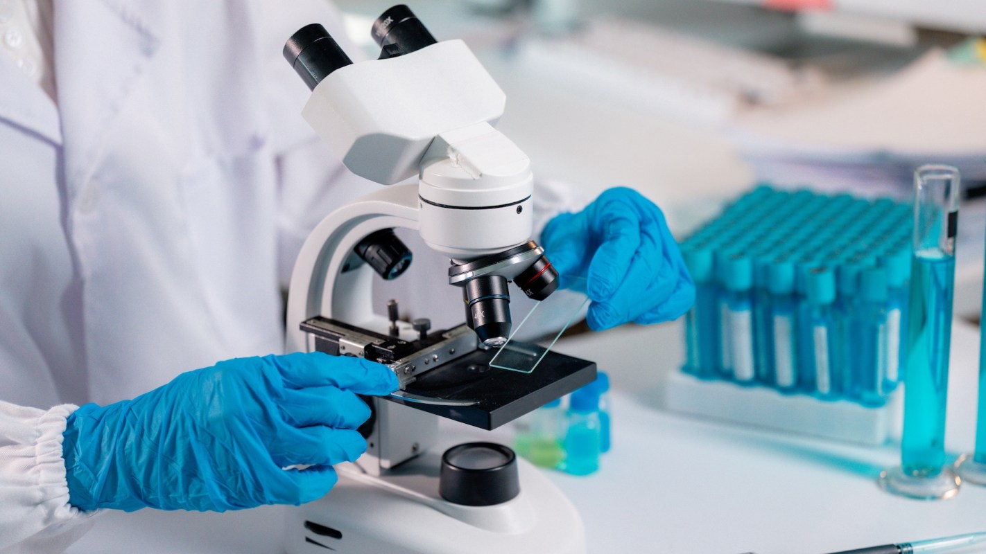 A researcher using a microscope.