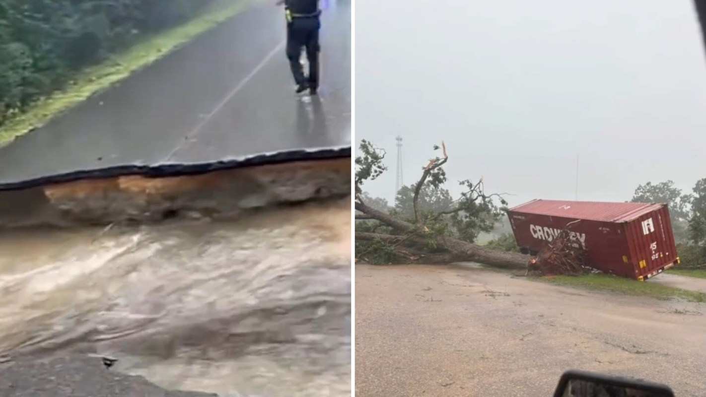 A sinkhole in a flooded road and a downed tree on top of a shipping container.