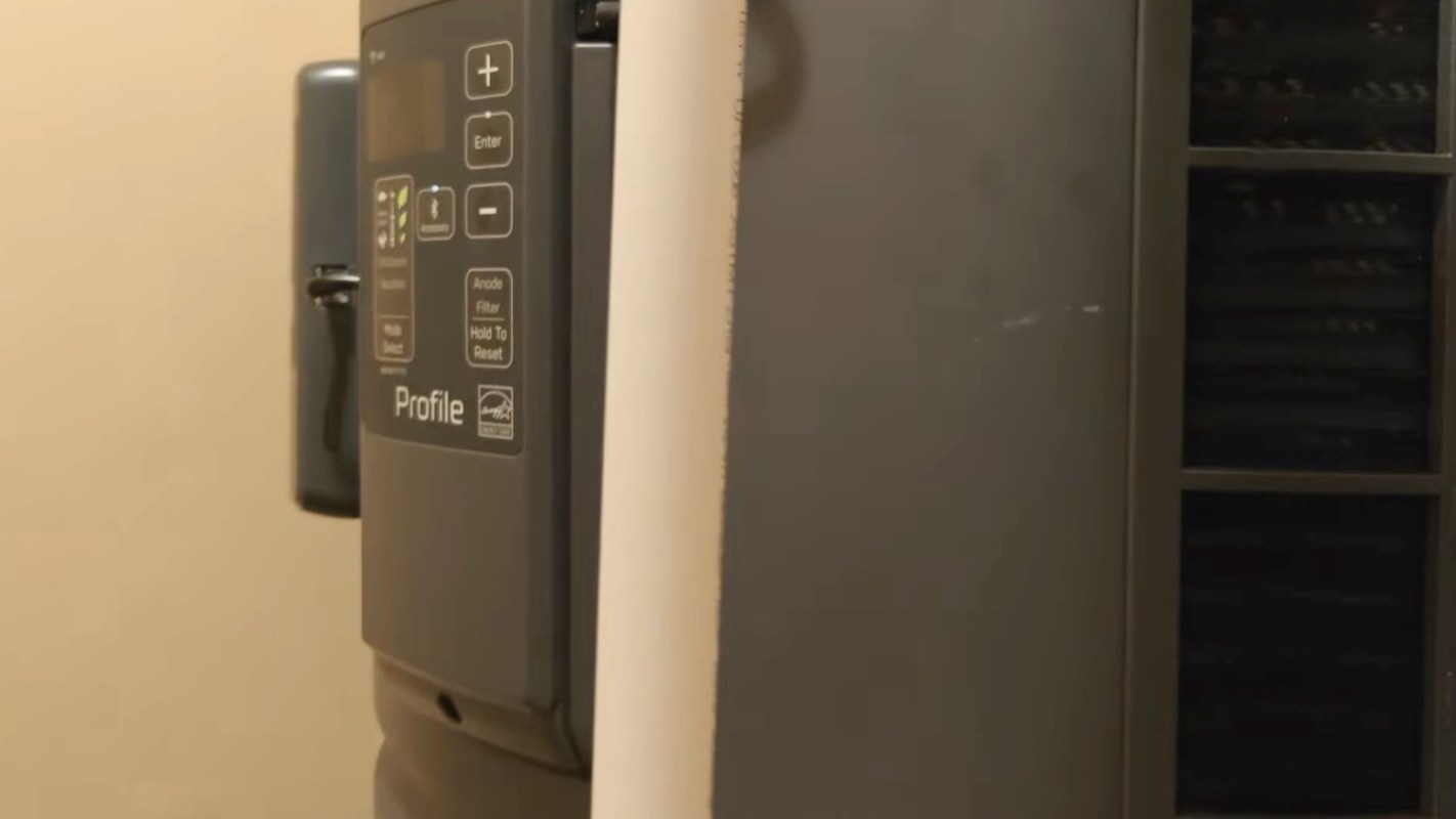 A gray appliance control panel beside a beige wall.