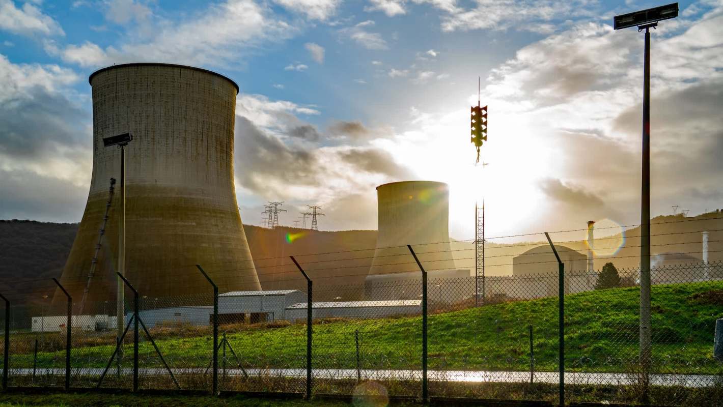 A nuclear power plant behind a barbed wire fence.