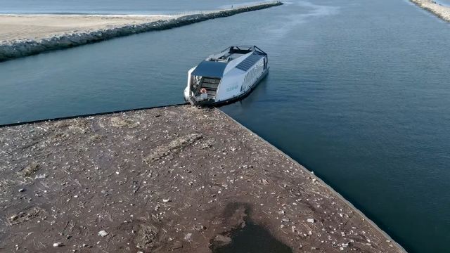 A boat is collecting debris from a waterway.