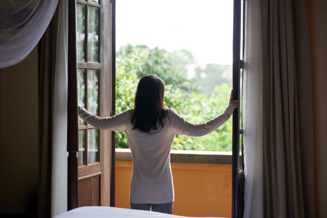 A person standing by an open window.