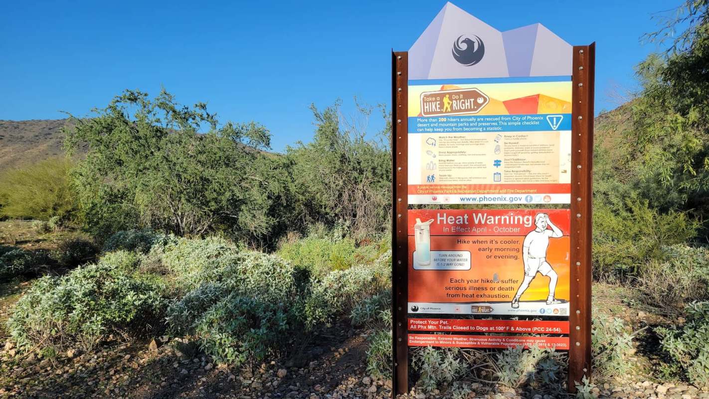 A heat warning sign on a hiking trail.