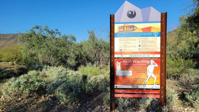 A heat warning sign on a hiking trail.