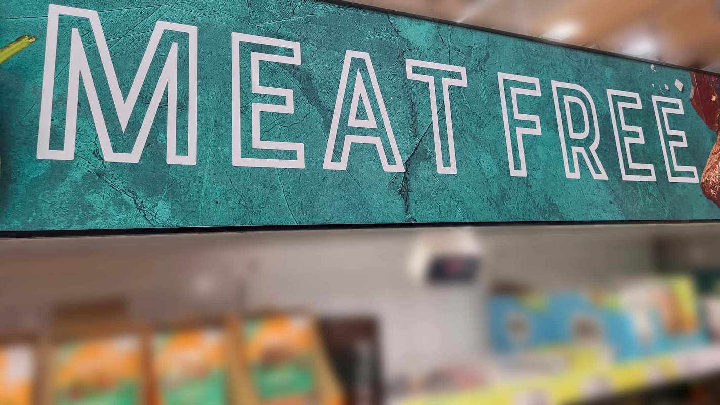 A sign reading "Meat Free" displayed in a grocery store.